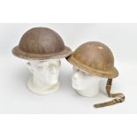 TWO BRITISH WORLD WAR TWO ERA HELMETS, one has the inner lining and chin strap, the other has