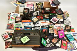 A BOX CONTAINING AN ATARI 2600 CONSOLE, GAMES, MANUALS AND CONTROLLERS, games include Donkey Kong,