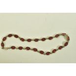 A WHITE METAL VARI COLOUR PASTE NECKLACE, comprising of twenty one oval shape red interspaced with