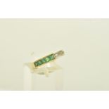 A YELLOW METAL EMERALD AND DIAMOND DRESS RING, of geometric design channel set with five graduated