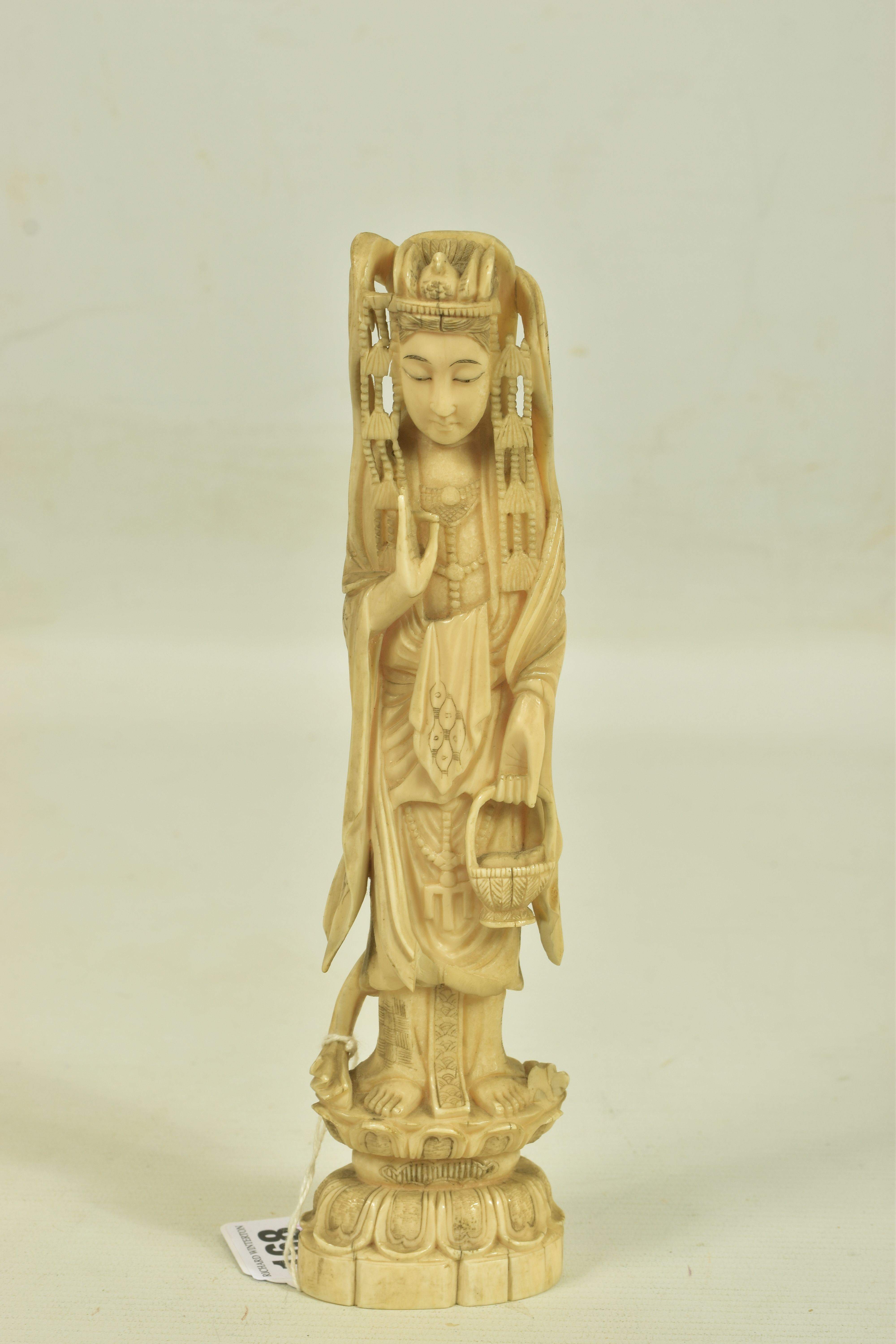 A LATE 19TH CENTURY CARVED IVORY FIGURE, depicting an oriental lady carrying a basket, with a bird