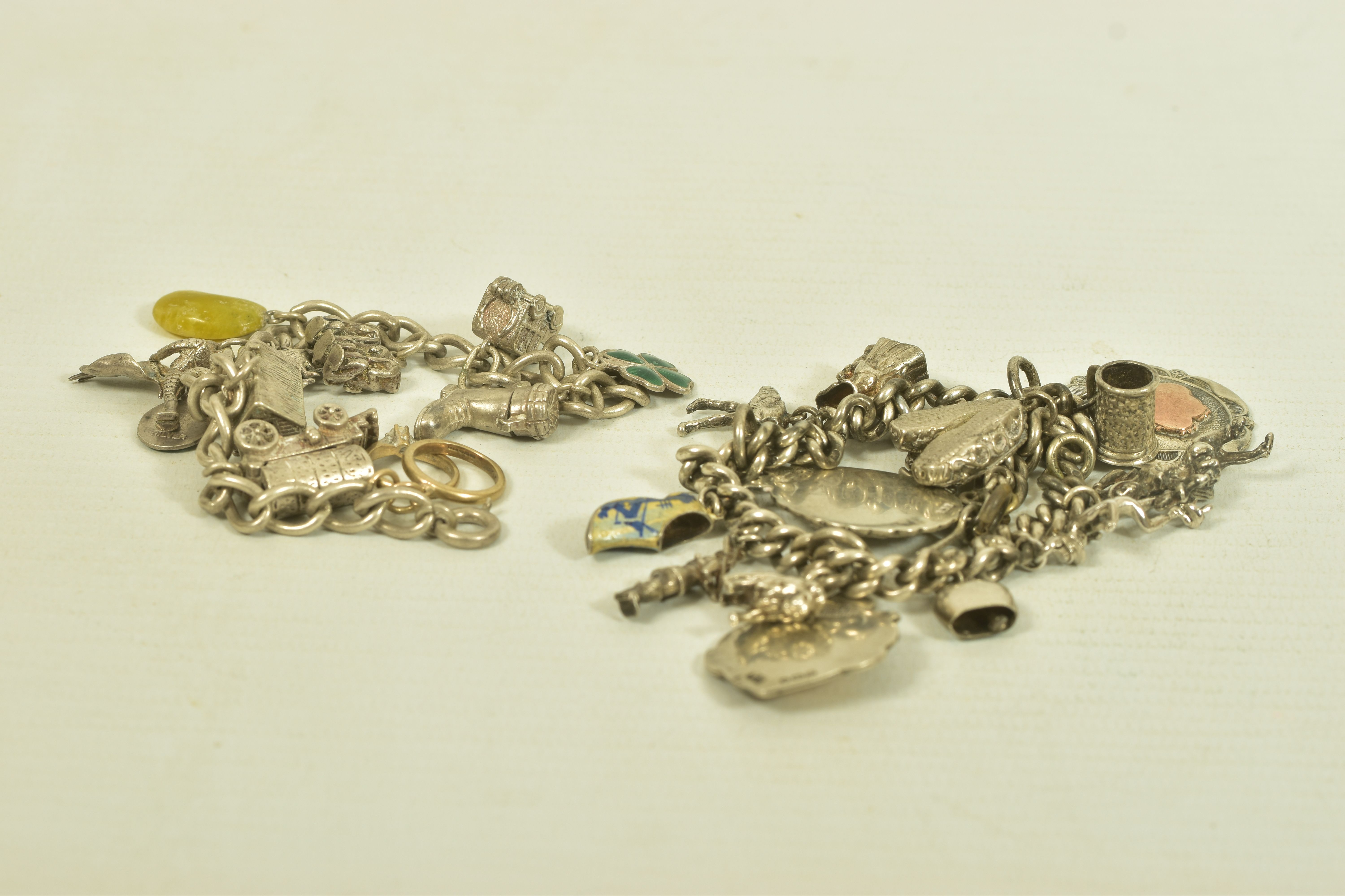 TWO MID 20TH CENTURY SILVER CHARM BRACELETS, the first comprising two cricket and football