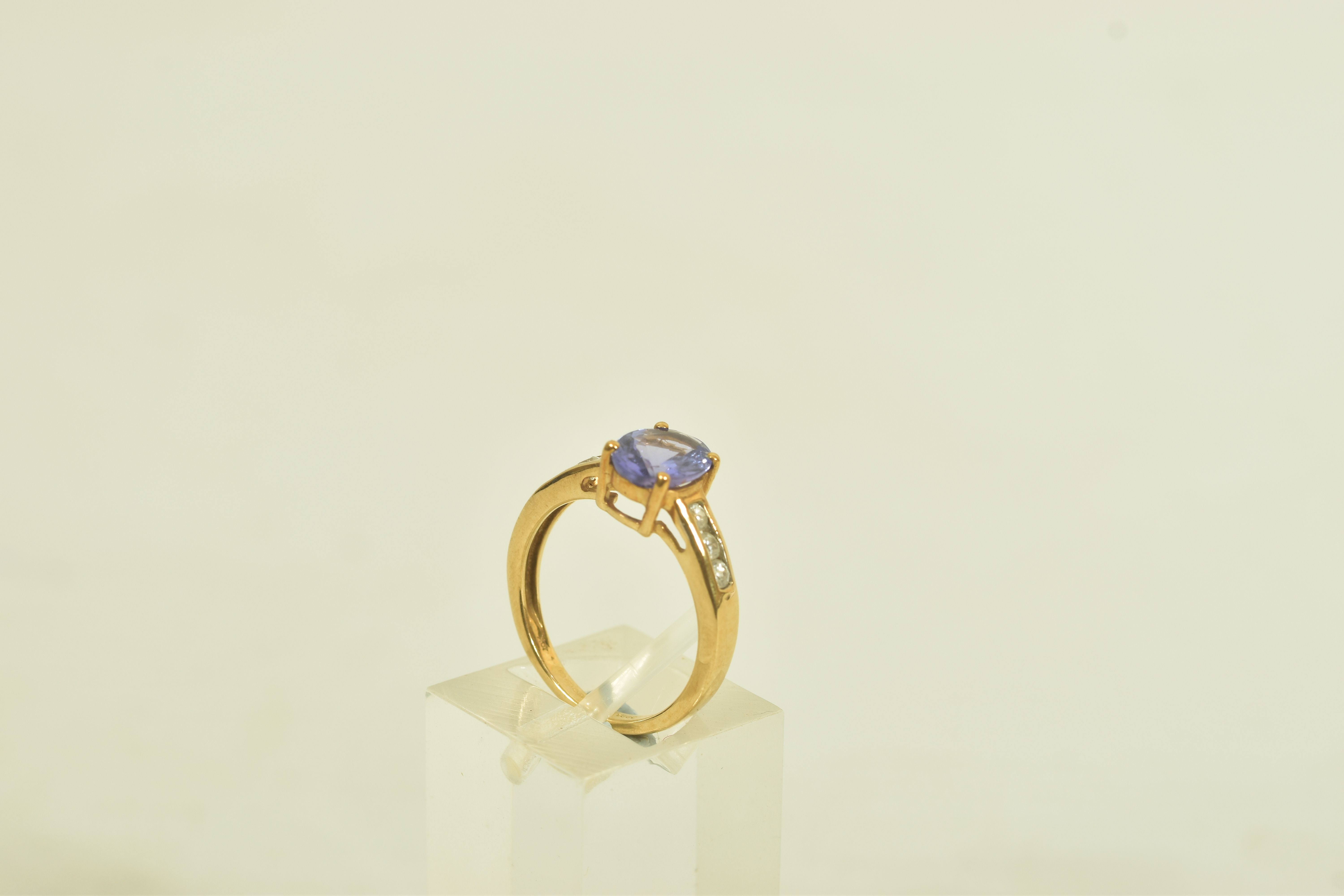 A 9CT GOLD TANZANITE AND COLOURLESS GEM DRESS RING, the oval tanzanite, to the circular colourless - Image 2 of 6