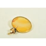 A YELLOW METAL BROOCH AND A CHARM, the first an oval shape carnelian brooch within a rope twist