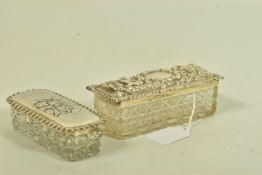 TWO EDWARDIAN SILVER BOXES, each designed as cut glass boxes with engraved and embossed cherub and