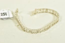 A WHITE METAL DIAMOND OPENWORK BRACELET, with a trilogy of brilliant-cut diamonds each interspaced