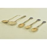 FIVE EARLY 20TH CENTURY SPOONS, to include three silver tea spoons with blue enamelled shield