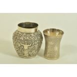 TWO WHITE METAL VASES, both of Indian design, the first decorated with raised foliate scenes,