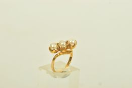 A YELLOW METAL CULTURED PEARL THREE STONE RING, of openwork design, comprising two split and one