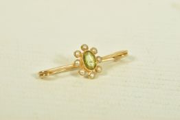 A YELLOW METAL PERIDOT AND SPLIT PEARL BAR BROOCH, the oval collet set peridot, within a split pearl