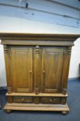 A MODERN OAK DOUBLE DOOR WARDROBE, overhanging cornice supported by three half columns, three