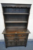 A SLIM REPRODUCTION OAK DRESSER, the top with a wavy apron with two plate rack shelves, two drawers,