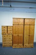 A PINE BEDROOM SUITE, comprising two double door wardrobes, with top boxes and a single drawer,