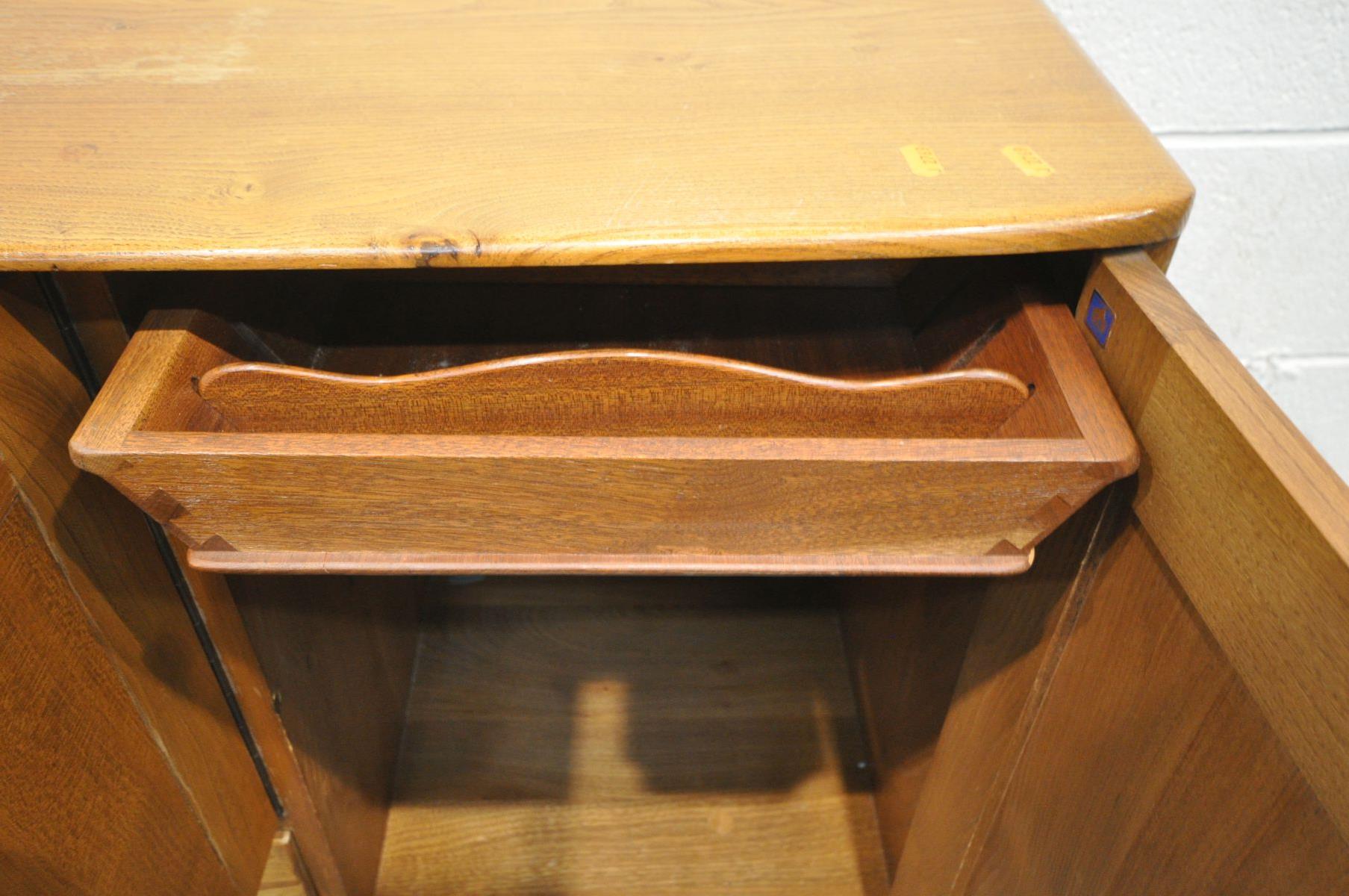 AN ERCOL MODEL 467 ELM AND BEECH SIDEBOARD, with double cupboard door above a single drawer, besides - Image 6 of 6