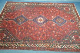 A 20TH CENTURY PERSIAN HAMADAN RUG, the red field within three medallions, and multi strap border,