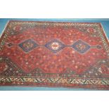 A 20TH CENTURY PERSIAN HAMADAN RUG, the red field within three medallions, and multi strap border,