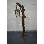 AN ARTS AND CRAFTS STYLE OAK STANDARD LAMP, with adjustable height clasp and a four sided glass