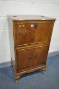 A WALNUT DRINKS CABINET, with a rise and fall top, over double cupboard doors, width 63cm x depth