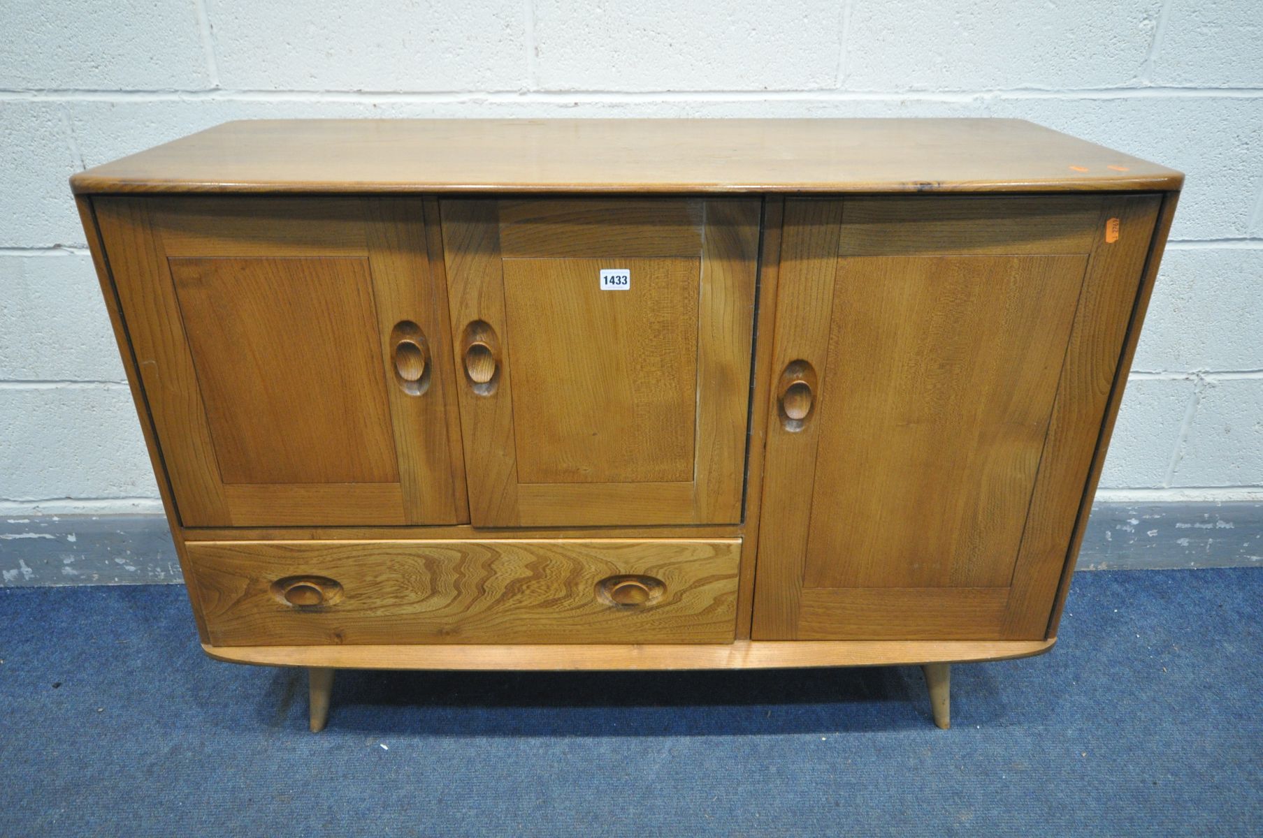 AN ERCOL MODEL 467 ELM AND BEECH SIDEBOARD, with double cupboard door above a single drawer, besides