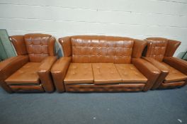 A BROWN LEATHERETTE BUTTONED THREE PIECE SUITE, comprising a three seater wing back sofa, length