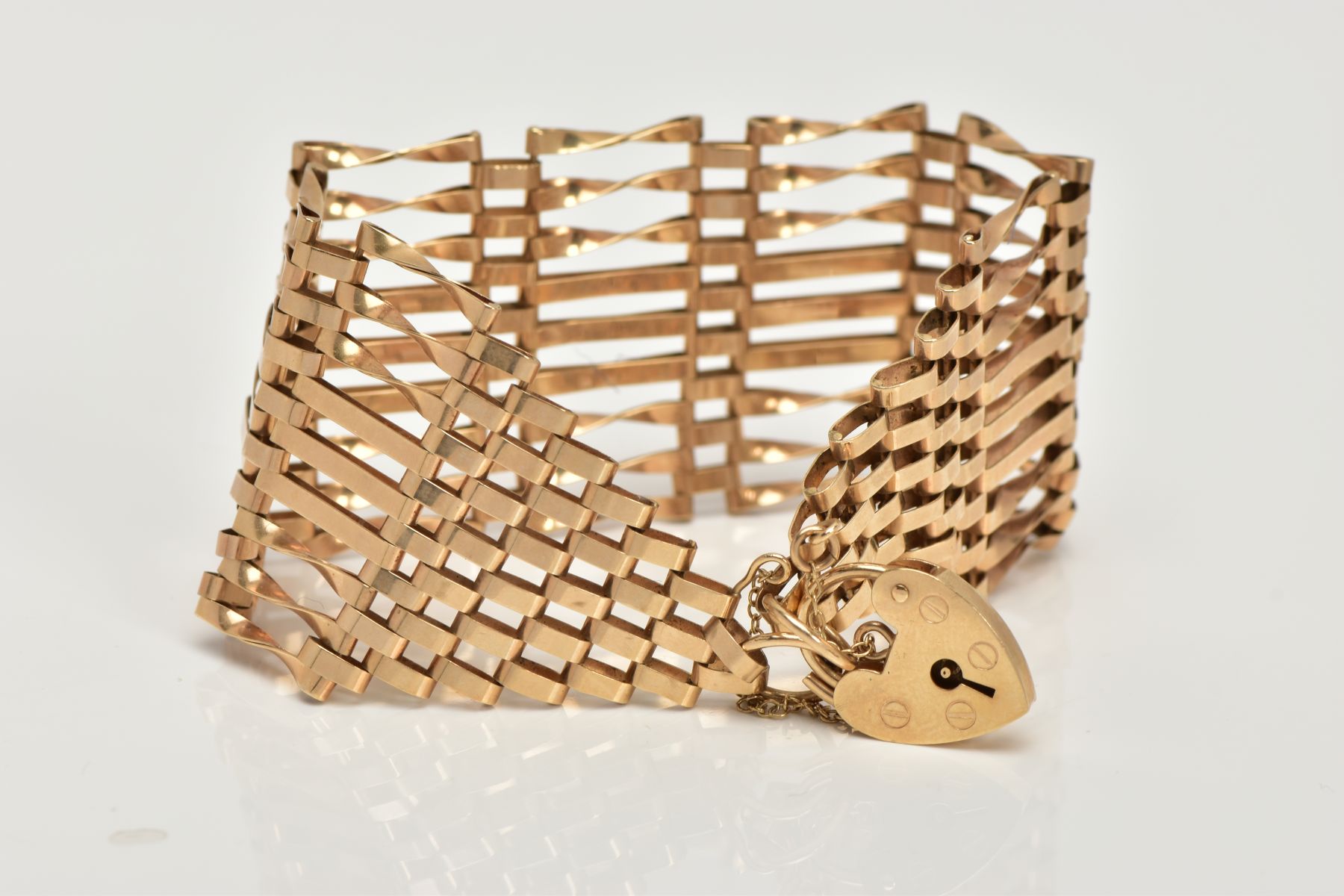 A 9CT GOLD GATE BRACELET, nine row gate bracelet, comprising of six twisted bars and three