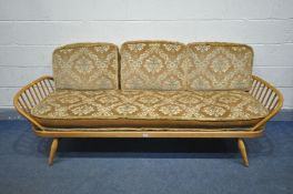 AN ERCOL MODEL 355 ELM AND BEECH STUDIO COUCH, with a surfboard back and spindled ends, with