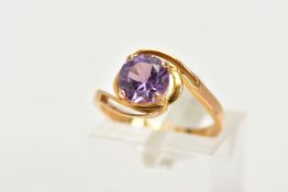 A YELLOW METAL GEM SET RING, a circular cut purple stone assessed as a synthetic colour change