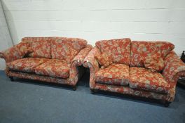 A RED FLORAL UPHOLSTERED LOUNGE SUITE, comprising of two sized sofas, length 198cm and 170cm x depth