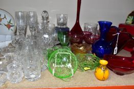 A GROUP OF COLOURED AND CLEAR GLASSWARES, to include a cranberry glass jug with white rim detail and