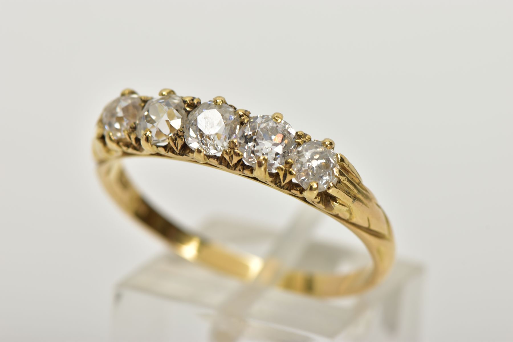 A YELLOW METAL FIVE STONE DIAMOND RING, designed with a row of five old cut diamonds, estimated