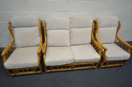 A WICKER THREE PIECE CONSERVATORY SUITE, comprising a two seater sofa and a pair of armchairs (