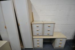 A CREAM FIVE PIECE BEDROOM SUITE, comprising a three door wardrobe, a desk with six drawers, a