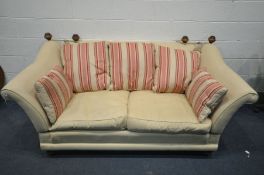 A KNOWLE STYLE CREAM UPHOLSTERED TWO SEATER SOFA, with tie back drop arms, on turned legs, width