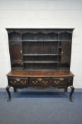 A GEORGIAN OAK DRESSER, the top with an arrangement of shelving flanked by a single cupboard,