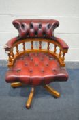 AN OXBLOOD LEATHER BUTTONED CAPTAINS CHAIR (condition - torn and missing leather to right arm)