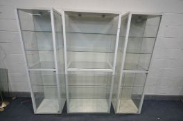 THREE TALL WHITE DISPLAY CABIETS, all with five shelves, one has four doors the other two have two