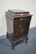 AN EDWARDIAN MAHOGANY MUSIC CABINET, with two doors enclosing five shelves, on ball and claw feet,