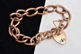 AN EARLY 20TH CENTURY ROSE GOLD CHARM BRACELET, large oval hollow links, fitted with a heart padlock