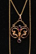 A YELLOW METAL LAVALIER PENDANT NECKLACE, openwork scroll pendant set with an oval cut amethyst in a