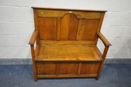 A 20TH CENTURY OAK HALL SETTLE, with open armrests, and a hinged lid storage compartment, labelled