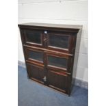 AN EARLY 20TH CENTURY MAHOGANY THREE TIER BOOKCASE, with two double glazed doors over a panelled