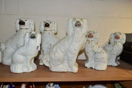 SIX STAFFORDSHIRE SPANIELS, white glazed with gilt details, comprising two pairs approximate heights