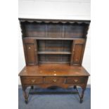 A EARLY TO MID 20TH CENTURY OAK DRESSER, the top with two cupboard doors, the base with three deep