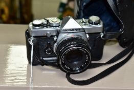 AN OLYMPUS OM-1 35MM SLR CAMERA, fitted with an Olympus Zuiko 50mm f1.8 lens, together with a