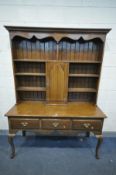 A 20TH CENTURY OAK DRESSER, with an arrangement of shelves, surrounding a cupboard door, over a base