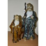 TWO CHINESE CERAMIC FIGURES, each holding a stick and a fruit, late twentieth century/