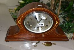 AN EDWARDIAN MAHOGANY AND INLAID MANTEL CLOCK, with a silvered oval dial (winding handle and