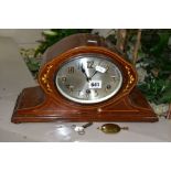 AN EDWARDIAN MAHOGANY AND INLAID MANTEL CLOCK, with a silvered oval dial (winding handle and
