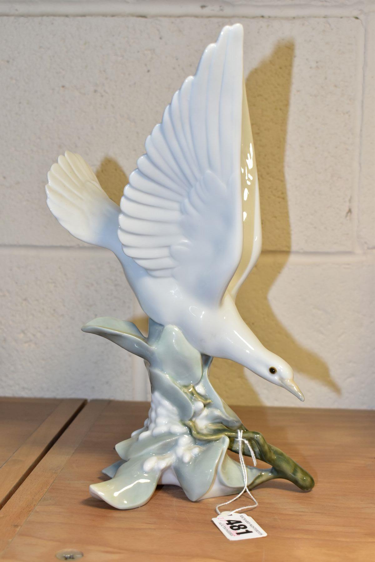 A LLADRO TURTLE DOVE, model no 4550, perched on leaves with wings raised, designed by Fulgencio
