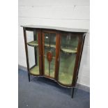 AN EDWARDIAN MAHOGANY AND MARQUETRY INLAID DISPLAY CABINET, with double bowfront cupboard doors,
